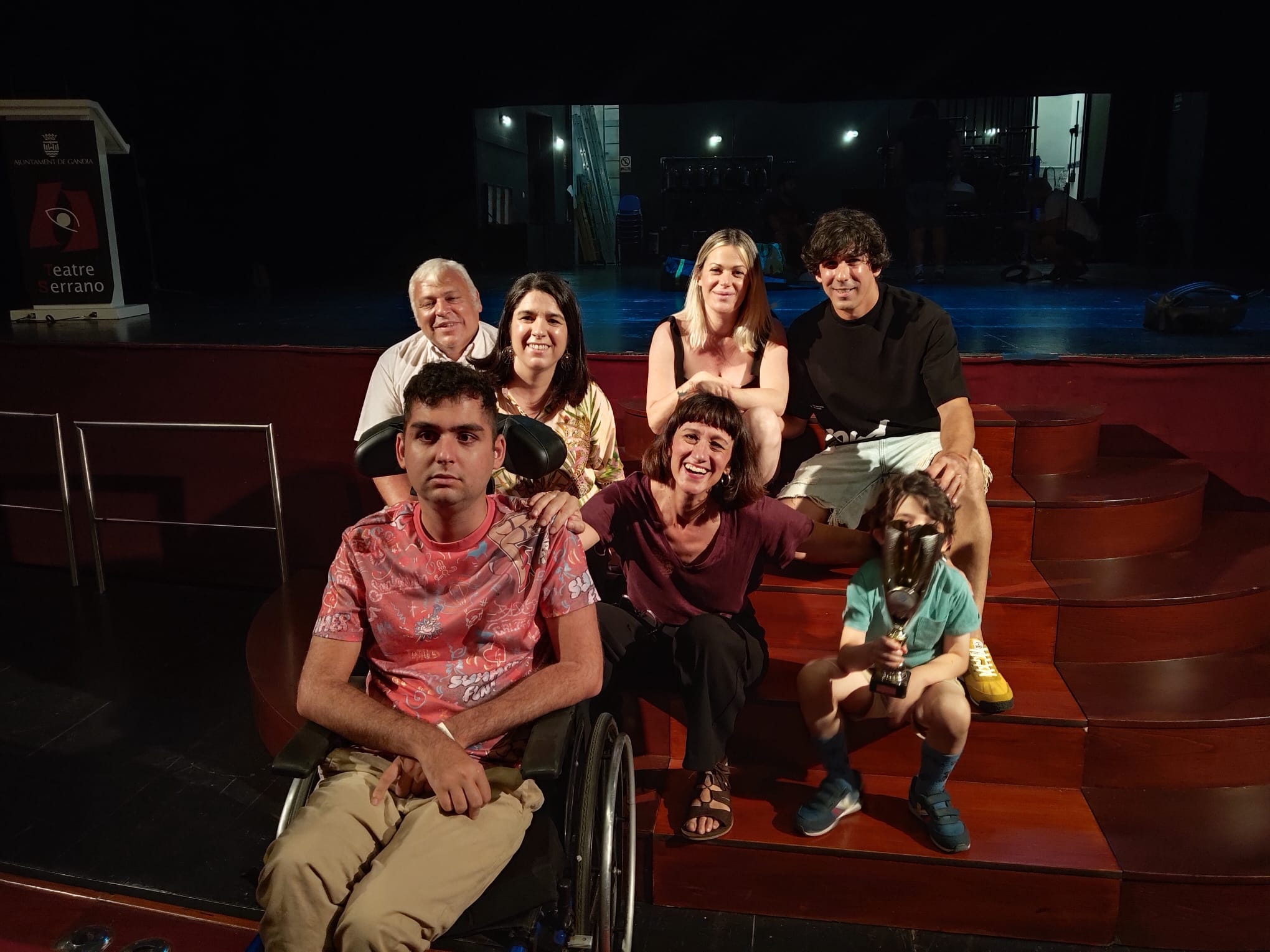 Alex y Kael, beneficiarios de la XIII campaña solidaria Adrián Orchillés, junto a sus padres y María Juan, monologuista animadora del acto.
